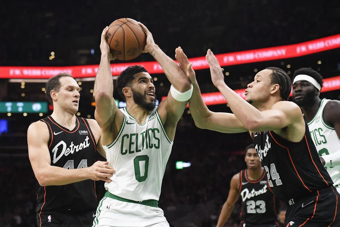 Boston Celtics forward Jayson Tatum drives to the basket while Detroit Pistons forward Kevin Knox II defends during the first half at TD Garden.