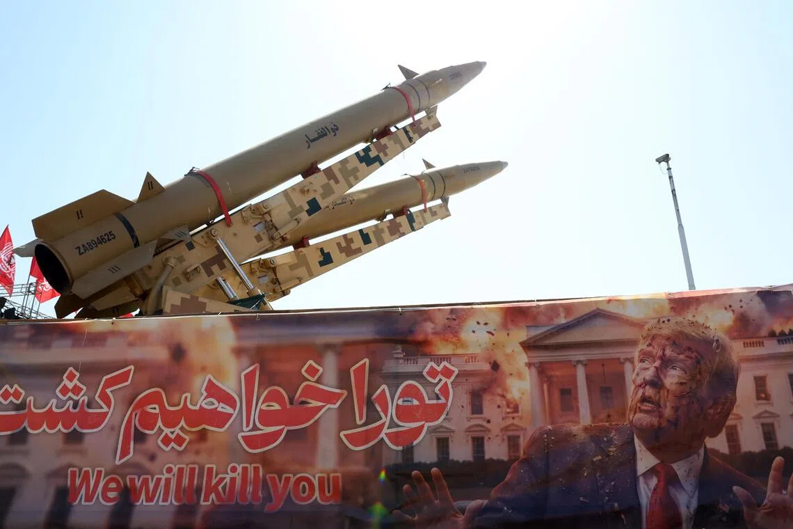 Iranian missiles are on display above a banner depicting US President Trump at Azadi Square in Tehran.