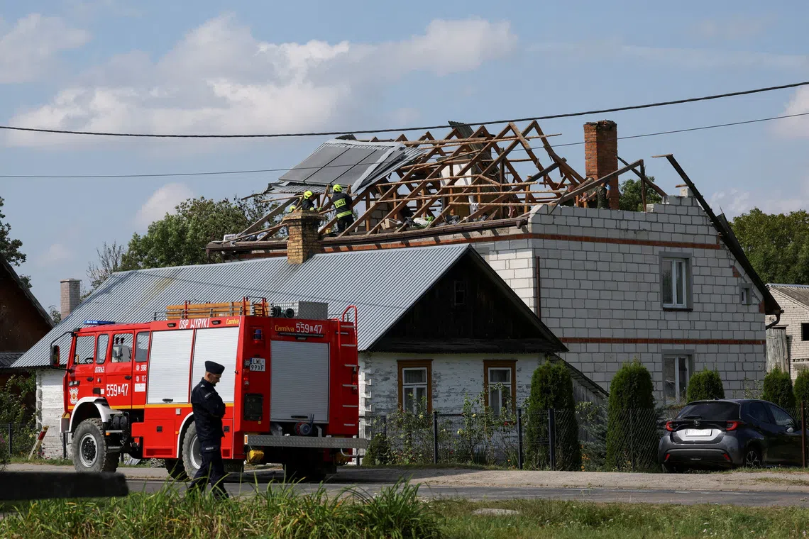 Firefighters working on the destroyed roof of a house in eastern Poland on Sept 10 after Russian drones violated Polish airspace during an attack on Ukraine.