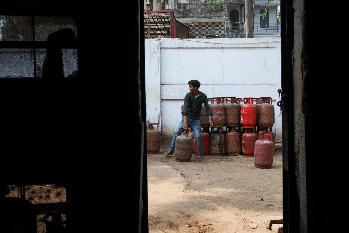 FILE PHOTO: A worker moves an LPG cylinder at a godown, amid supply disruptions following the U.S.-Israeli conflict with Iran, in New Delhi, India, March 10, 2026. REUTERS/Bhawika Chhabra/File Photo