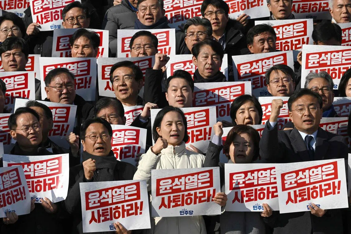 South Korea's main opposition Democratic Party members hold placards reading "Yoon Suk Yeol should resign!" during a rally on Dec 4.