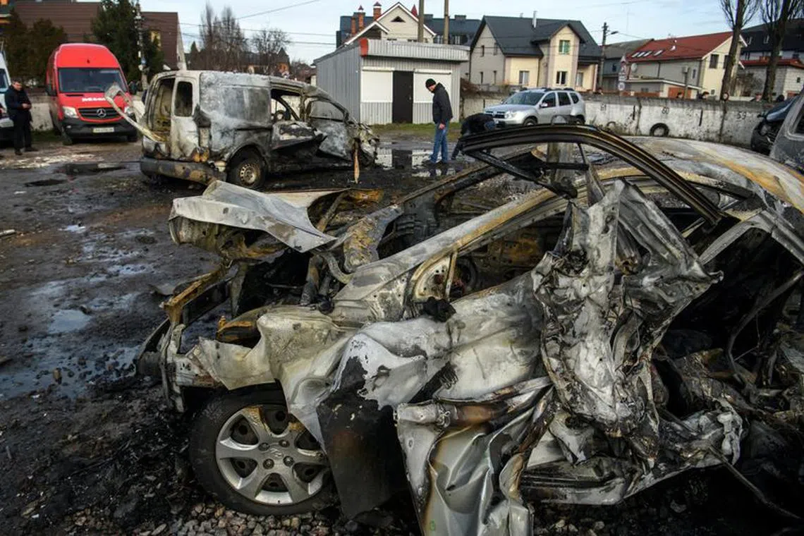 A man walks next to a car destroyed during a Russian missile and drone strike, amid Russia's attack on Ukraine, in Kyiv, Ukraine December 29, 2023. REUTERS/Vladyslav Musiienko