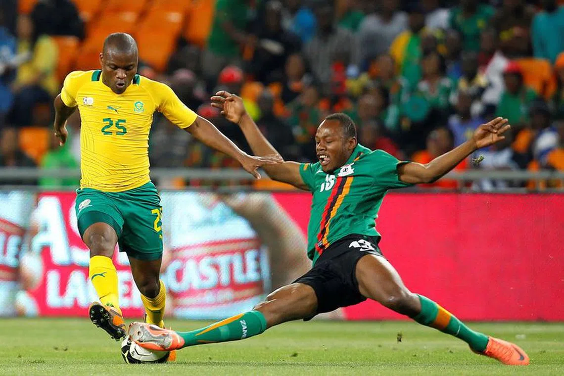 FILE PHOTO: Zambia's Stoppila Sunzu (R) challenges Tokelo Rantie of South Africa during the Nelson Mandela Challenge at Soccer city outside Soweto, November 14 2012.   REUTERS/Siphiwe Sibeko   (SOUTH AFRICA - Tags: SPORT SOCCER)/File Photo
