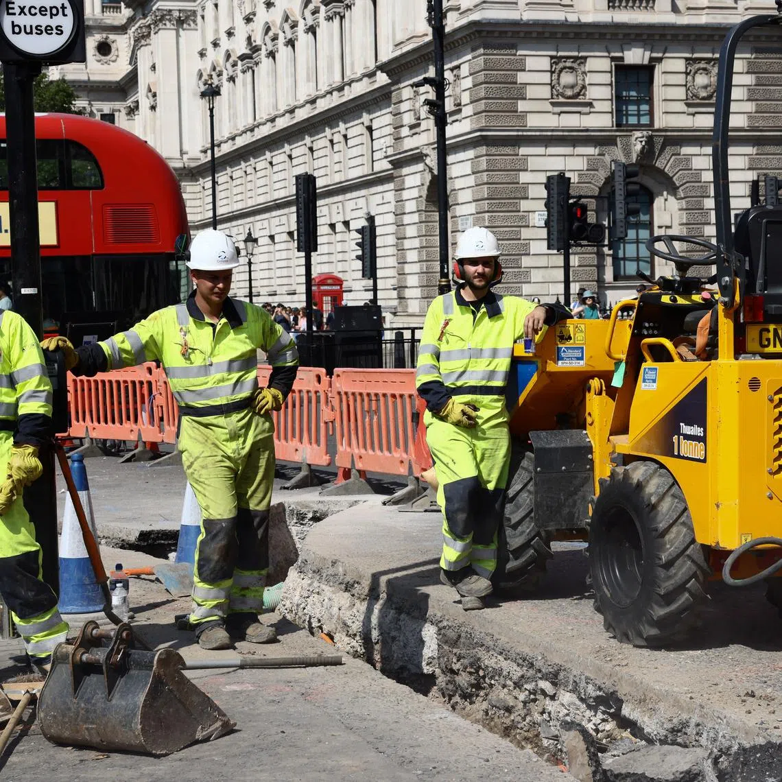 FILE PHOTO: Workmen pause as they dig up a section of road in Westminster during a heatwave, in London, Britain, August 12, 2025. REUTERS/Jack Taylor/File Photo