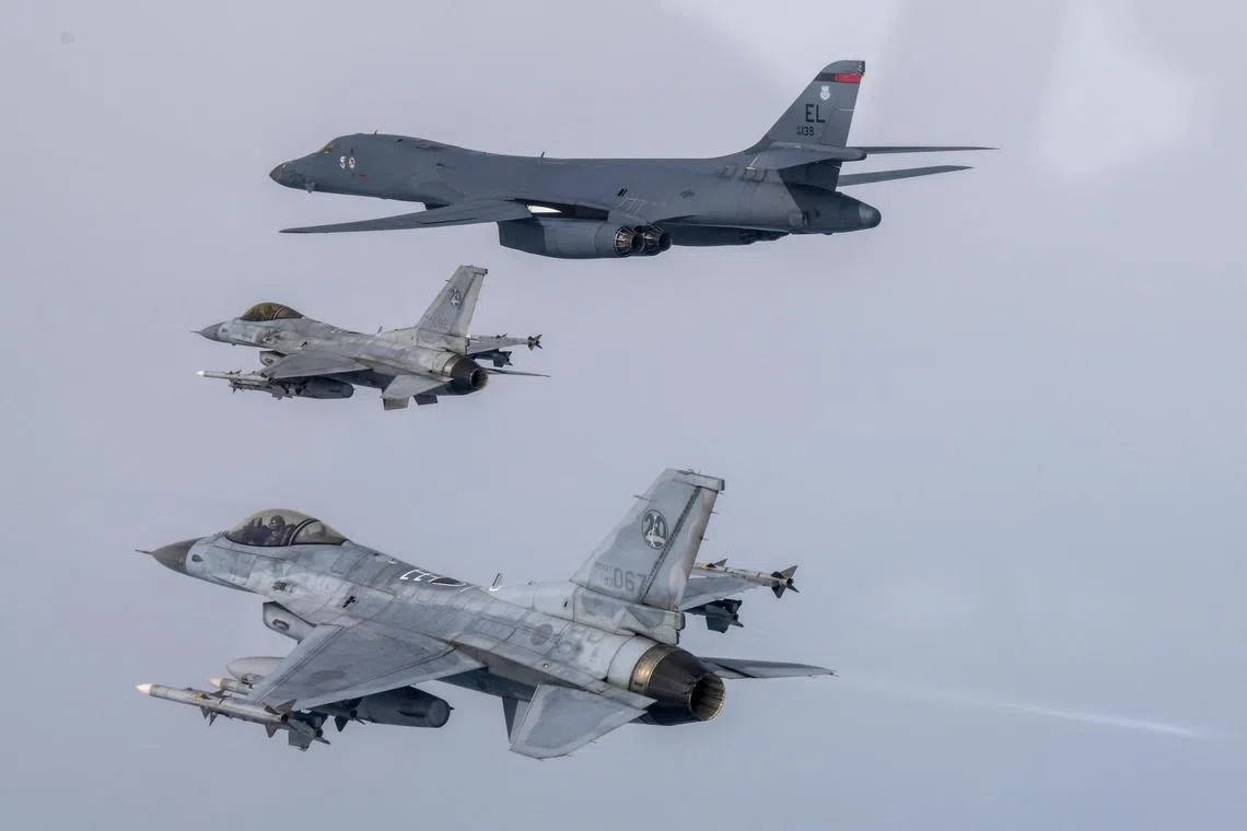 A US Air Force B-1B bomber (top) and South Korean KF-16 fighter jets take part in a joint air drill in South Korea, on March 3, 2023. 