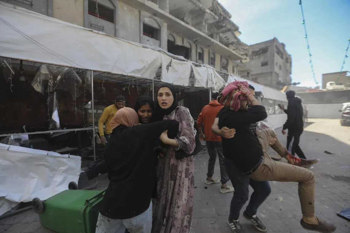 People in the aftermath of an Israeli drone strike at a restaurant in Gaza City, on May 7.