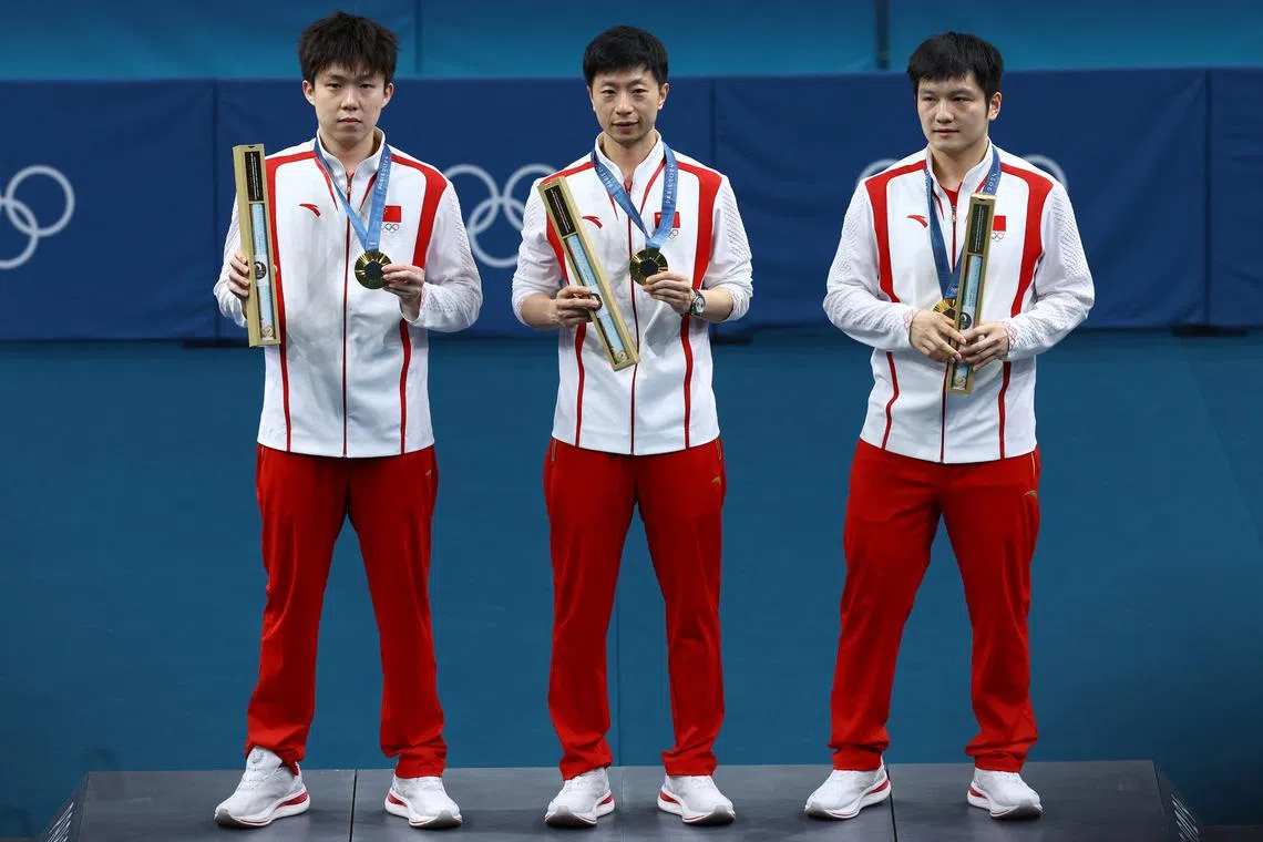Paris 2024 Olympics - Table Tennis - Men's Team Victory Ceremony - South Paris Arena 4, Paris, France - August 09, 2024. Gold medallists team of China, Long Ma of China, Chuqin Wang of China, and Zhendong Fan of China celebrate on the podium after winning. REUTERS/Stephanie Lecocq