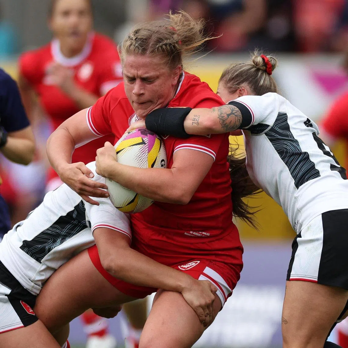 Canada's hooker Emily Tuttosi is tackled in the Women’s Rugby World Cup pool B match against Wales at Salford Community Stadium in Manchester on Aug 30, 2025.