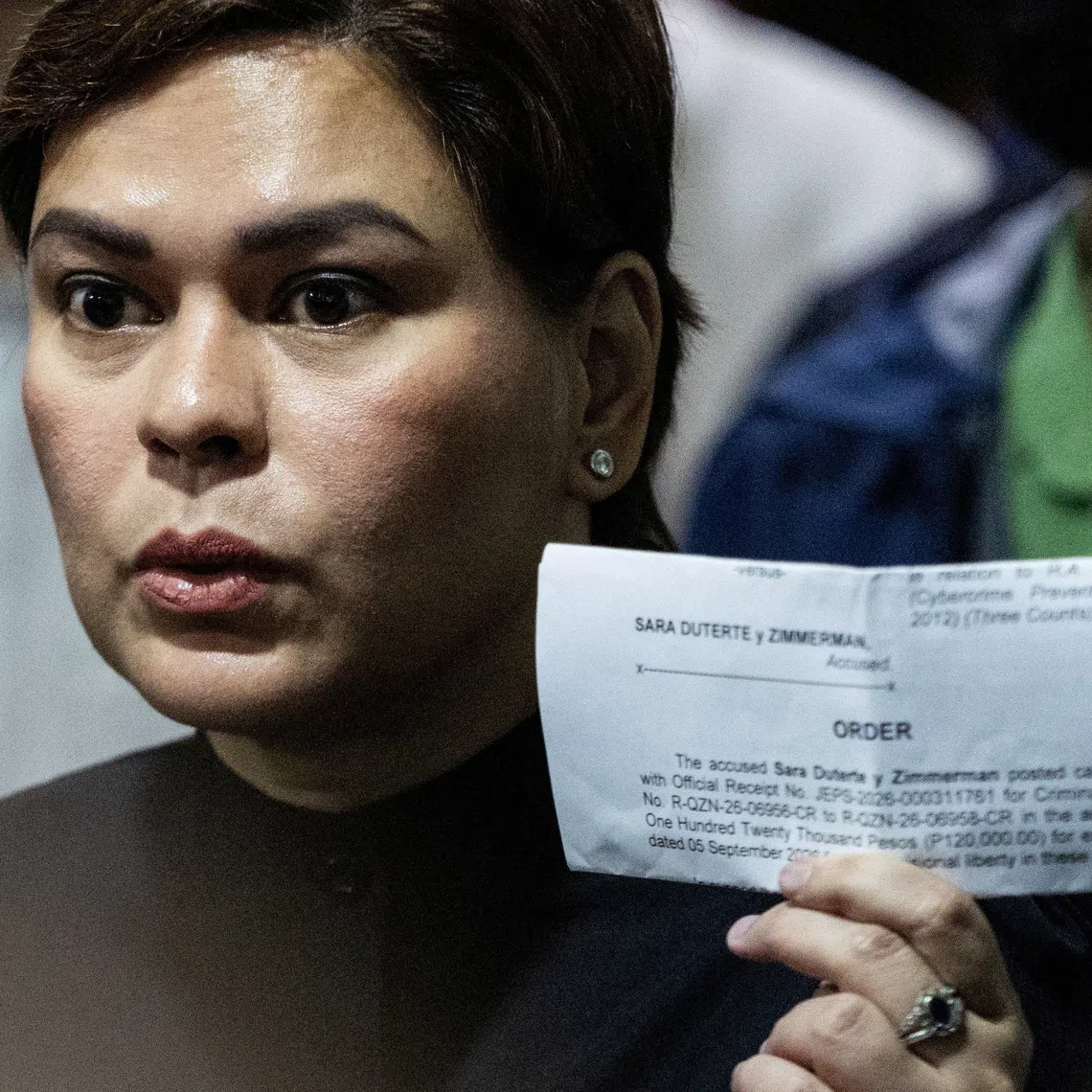 Philippine Vice President Sara Duterte shows members of the media a court order confirming she posted bail at the Quezon City Regional Trial Court, a day after a court ordered her arrest, in Quezon City, Philippines, September 5, 2026. REUTERS/Eloisa Lopez