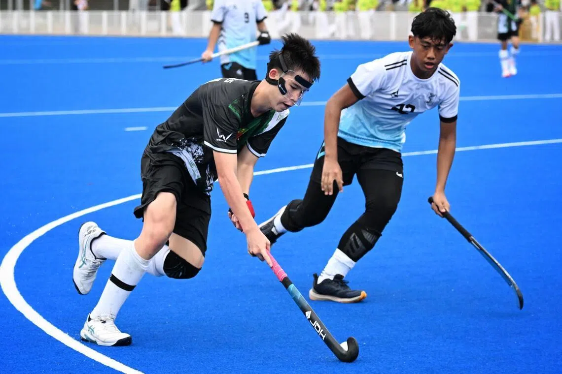 Gabriel Teoh (left) of RI hockey team in action during the National Schools Games hockey B Division boys' final against Sengkang Secondary School on April 20, 2026.