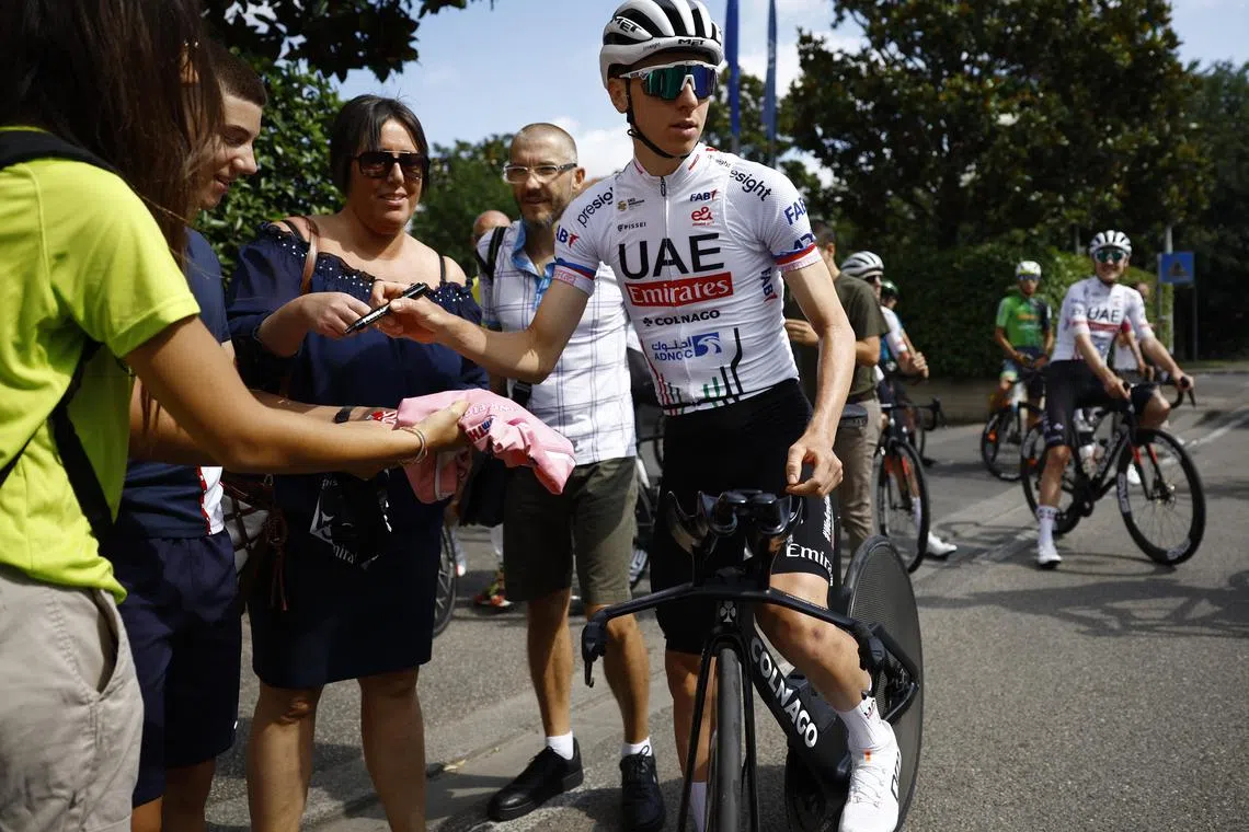Team UAE's Tadej Pogacar signs autographs for fans before training for the Tour de France on June 27, 2024.