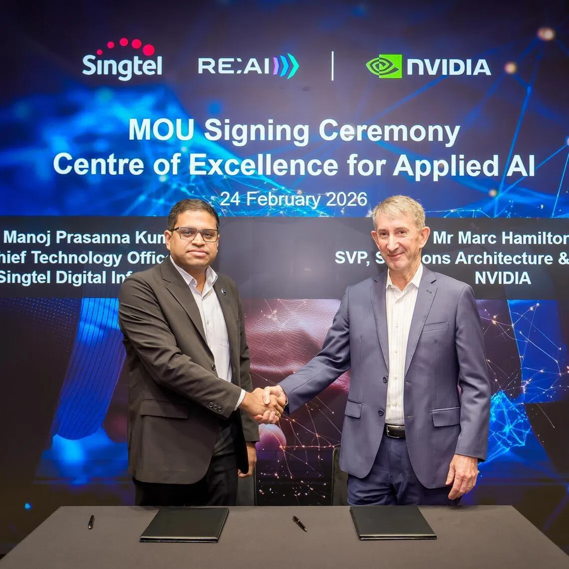 A handshake to tie the launch of their Centre of Excellence for Applied AI.  (From left) Mr Manoj Prasanna Kumar , chief technology officer (CTO) of Singtel Digital InfraCo and Nvidia’s senior vice‑president of solutions architecture and engineering Marc Hamilton.

PHOTO: SINGTEL