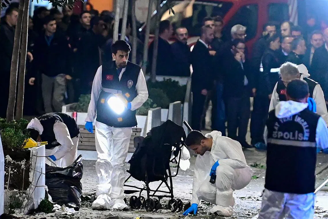 Members of the crime scene investigation police work as Turkish policemen secure the area after a strong explosion of unknown origin shook the busy shopping street of Istiklal in Istanbul, on Nov 13, 2022.