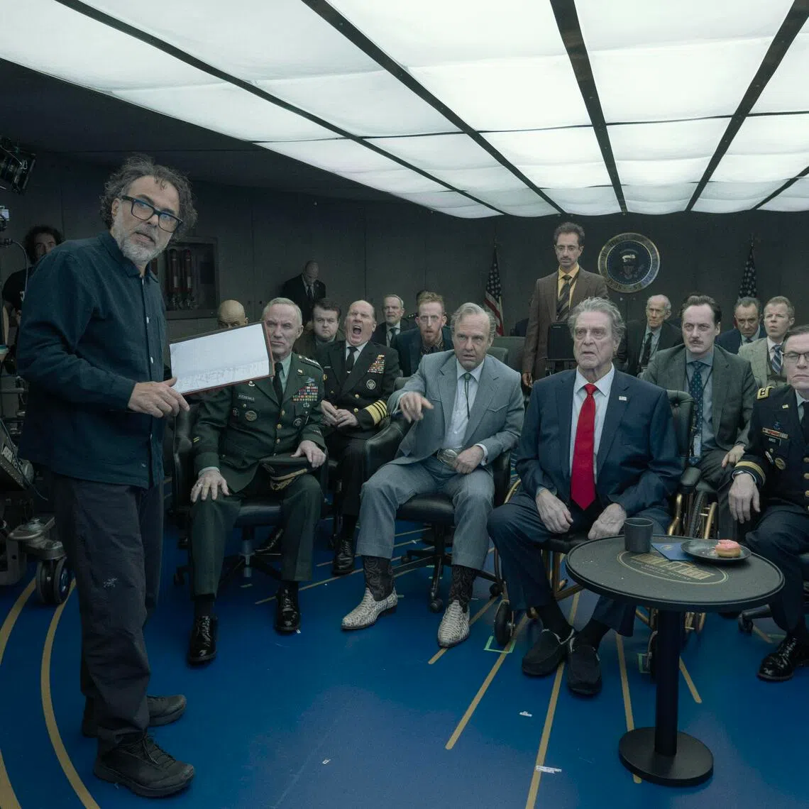 Director Alejandro Gonzalez Inarritu (left) with actors Tom Cruise (seated centre in grey suit) and John Goodman (with red tie) on the set of Digger.