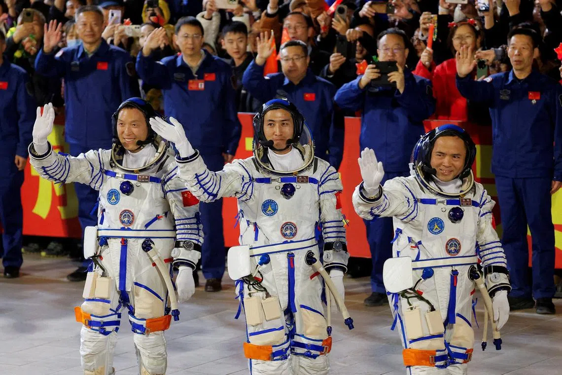 Three crew members of Shenzhou-21 spaceflight mission wave during a see-off ceremony on Oct 31, 2025.