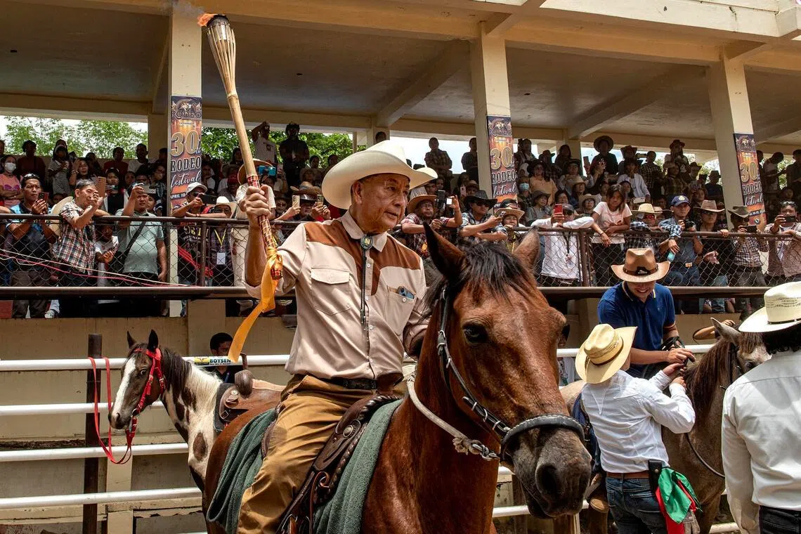 Rodeo Masbateno Inc president Manuel Sese lights the torch while on horseback to signal the start of the festival on April 13.