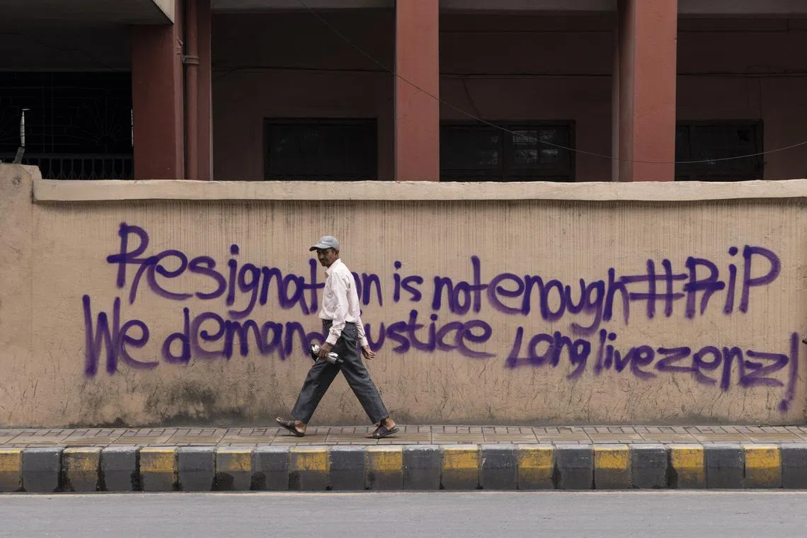 A person walks in front of a wall with a message from protesters in Kathmandu, Nepal, on Sept 10, 2025.