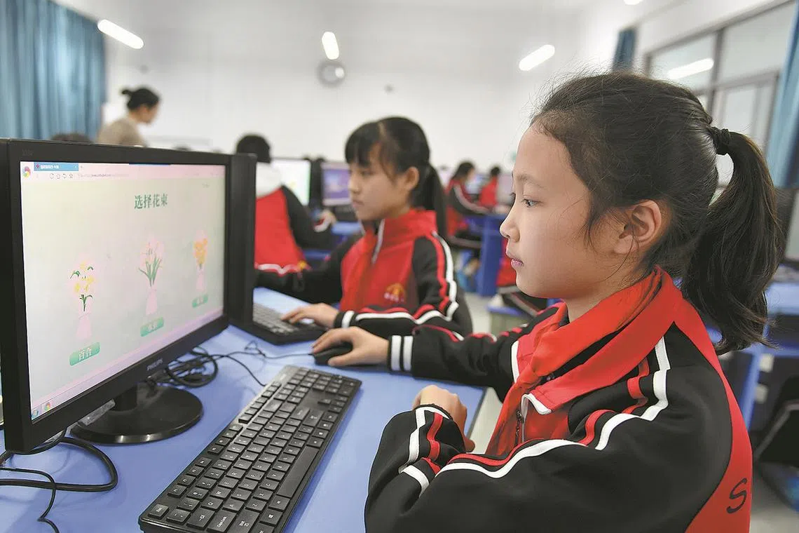 Students pay respect to the deceased through a website at their school in Zigui, Hubei province.