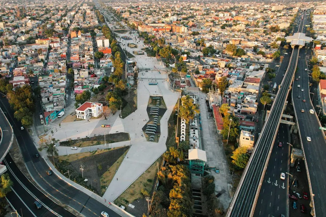 An aerial view showing Parque Lineal Gran Canal (on the left) and a metro station (on the right) in Mexico City.