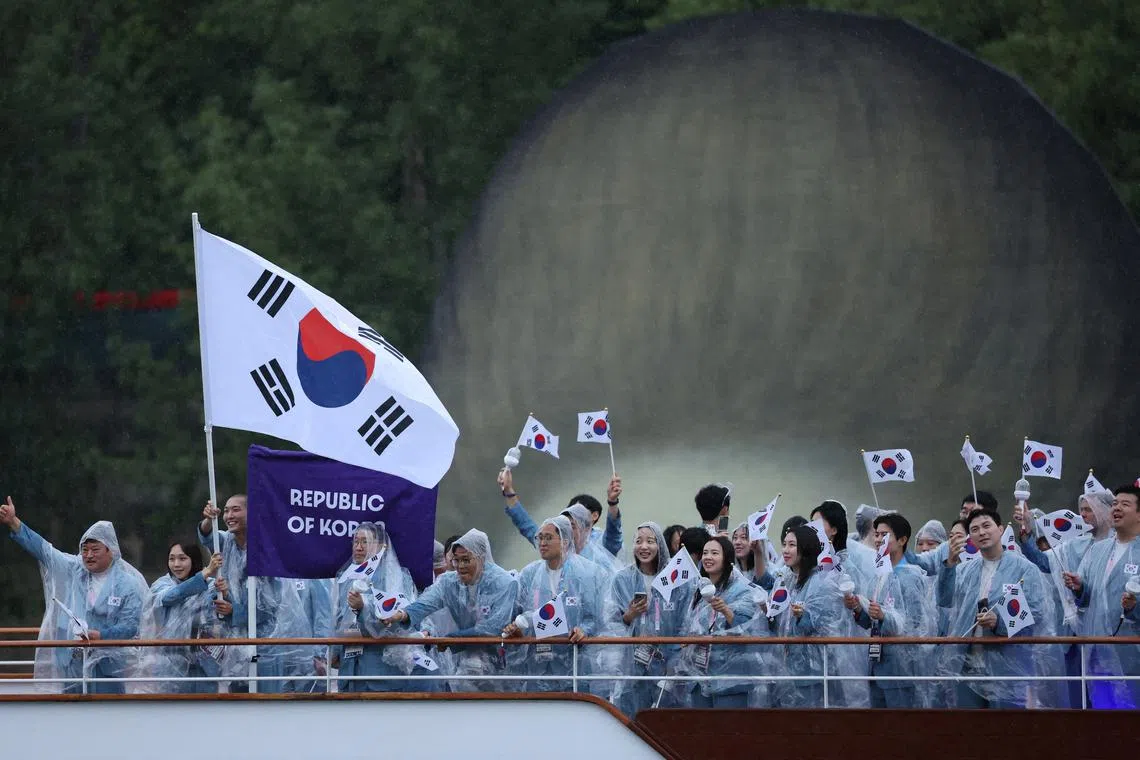 FILE PHOTO: Paris 2024 Olympics - Opening Ceremony - Paris, France - July 26, 2024. Athletes of South Korea aboard a boat in the floating parade on the river Seine during the opening ceremony. REUTERS/Claudia Greco/File Photo