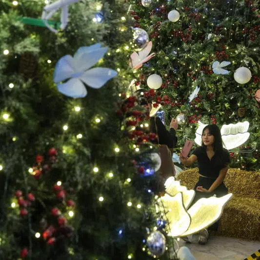  A woman taking a selfie near the Christmas decorations displayed in Kuala Lumpur, Malaysia, on Dec 19.