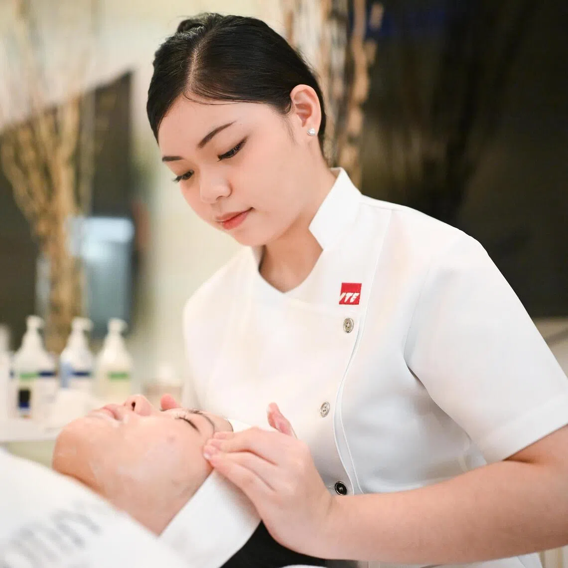 Winnalyn Tay, a third-year Higher Nitec in beauty and wellness management student at ITE College East, practising a facial treatment on her coursemate.