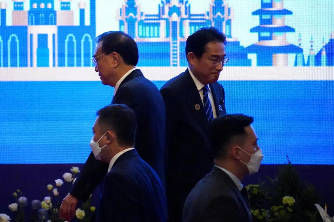 Chinese Premier Li Keqiang and Japan's Prime Minister Fumio Kishida pass each other at the Asean summit held in Phnom Penh, on Nov 12, 2022.
