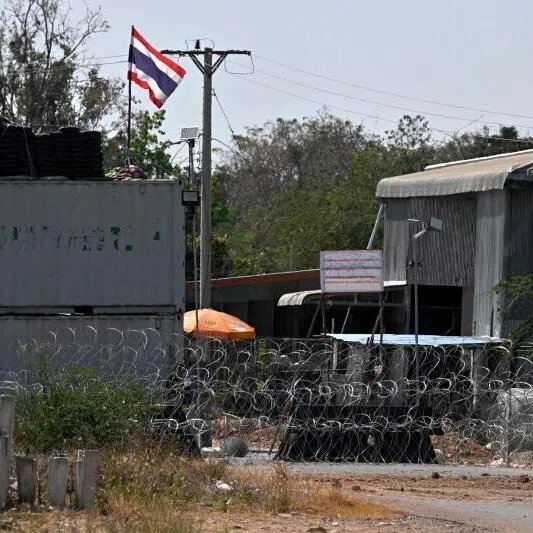 A Thai flag displayed on shipping containers installed by Thai forces, with a hanging sign proclaiming: "Cambodian citizens are strictly prohibited from entering this area."