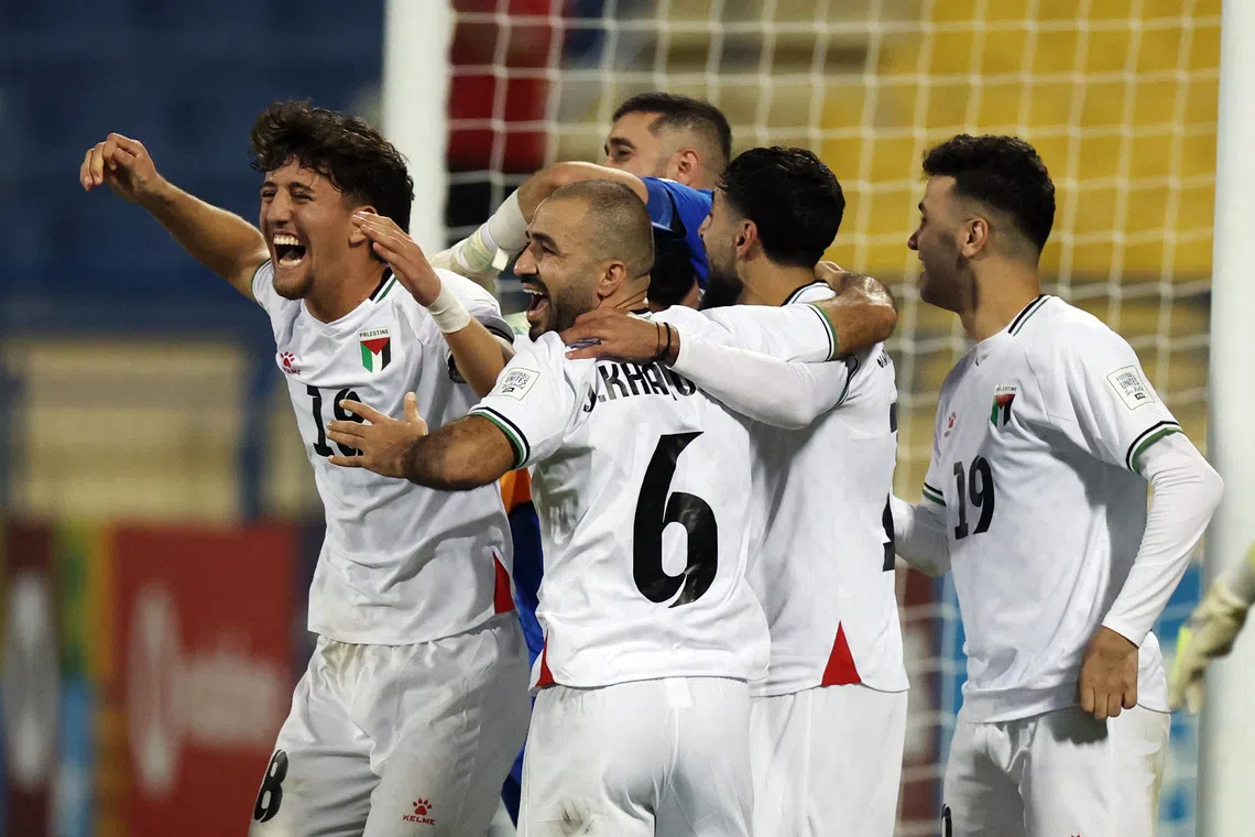 Soccer Football - FIFA Arab Cup - Qatar 2025 - Qualifying - Palestine v Libya - Thani bin Jassim Stadium, Al Rayyan, Qatar - November 25, 2025 Palestine's Oday Kharoub and Ahmad Al Qaq celebrate with teammates after winning the penalty shootout REUTERS/Mohammed Salem