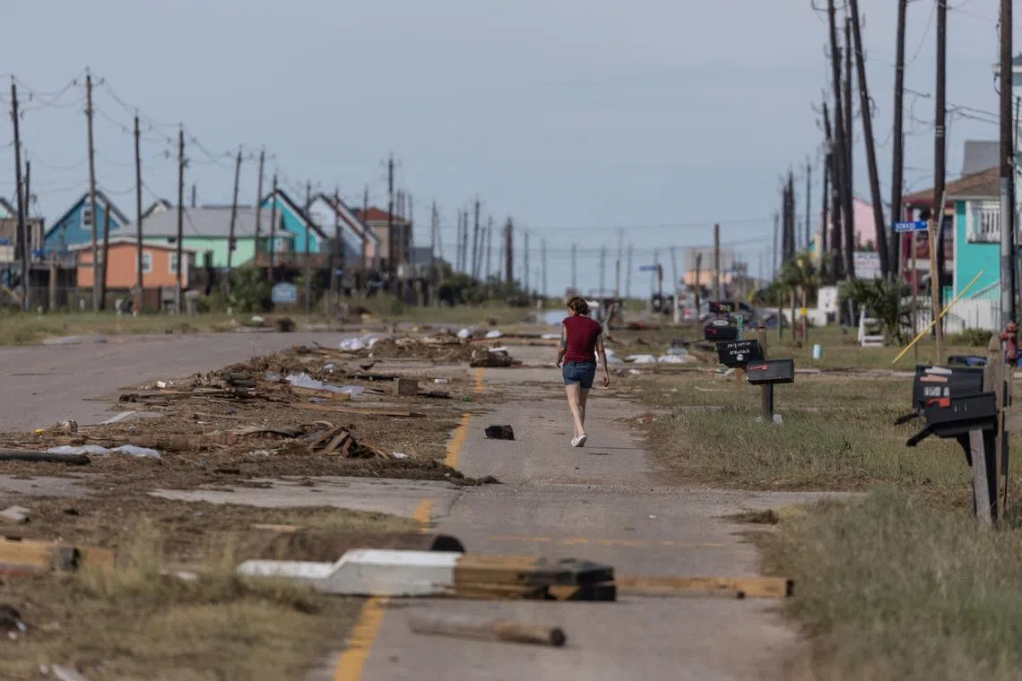 A resident walks past debris in the aftermath of Hurricane Beryl in Surfside Beach, Texas, U.S., July 8, 2024.  REUTERS/Adrees Latif