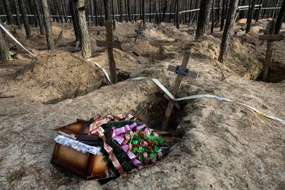 Bodies are exhumed from mass graves in the Ukrainian city of Izyum, in 2023, after Russian forces were driven out of the city.