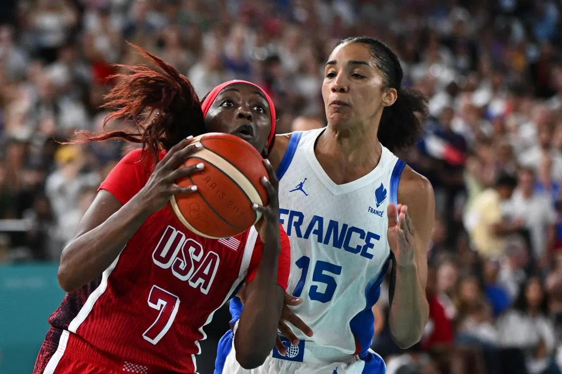 USA's Kahleah Copper goes to the basket past France's Gabby Williams in the women's Gold Medal basketball match.