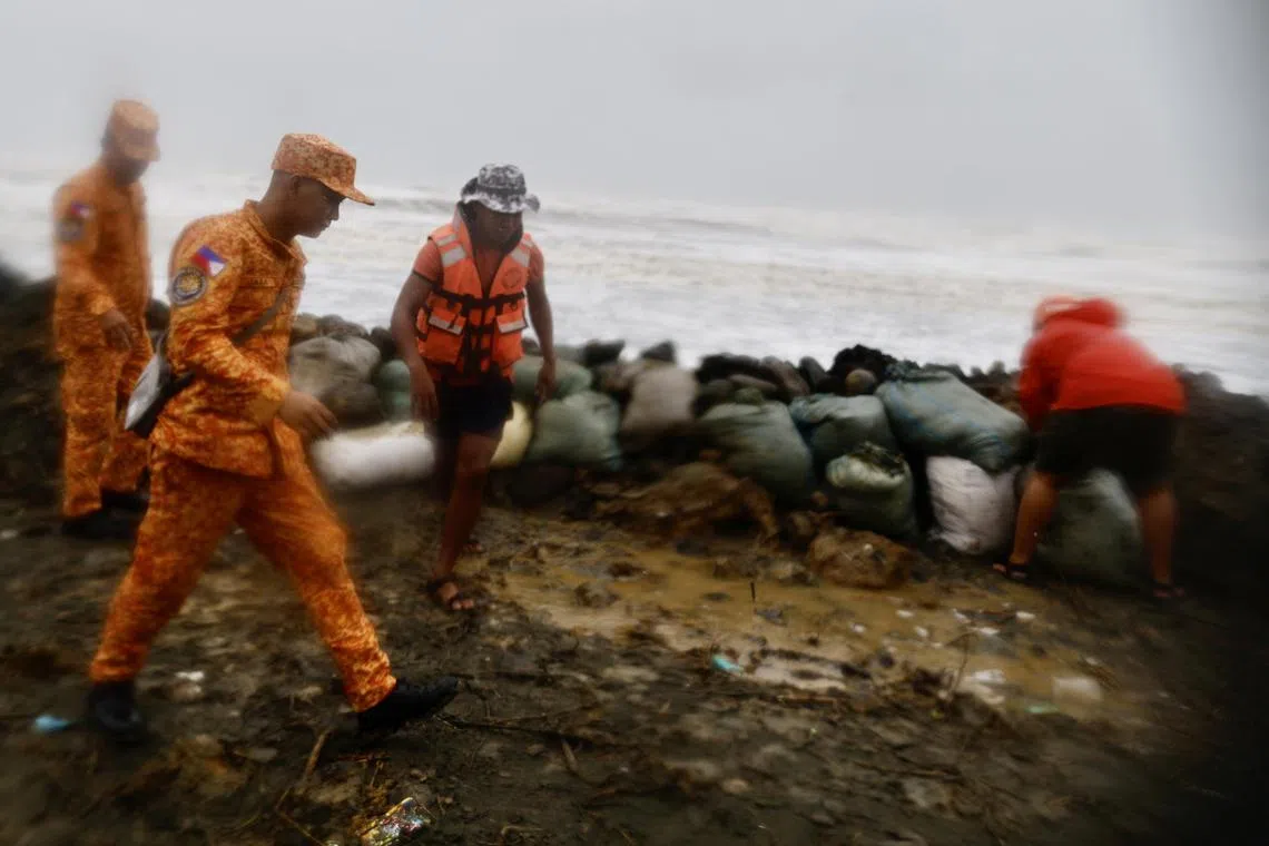 Coastguard personnel rush to repair a damaged storm surge barrier in the coastal town of Buguey, Cagayan province, Philippines, on Nov 7, 2024.