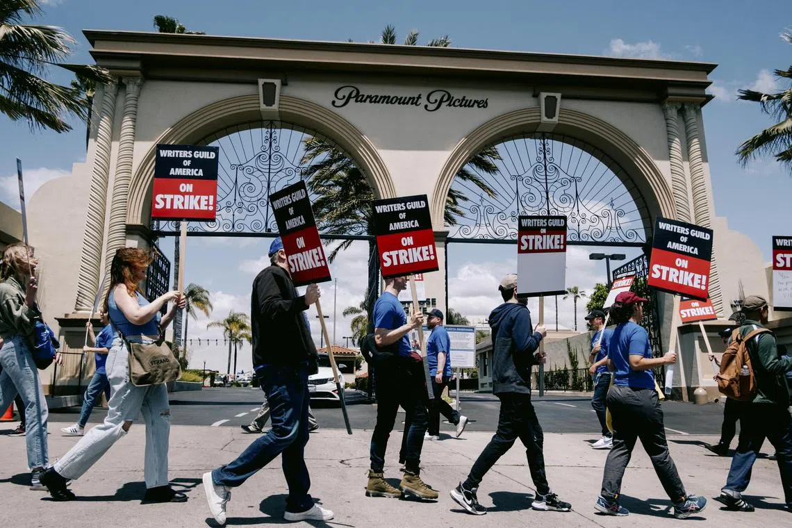Members of the Writers Guild of America walk the picket line outside Paramount Studios in Los Angeles on Tuesday. 
