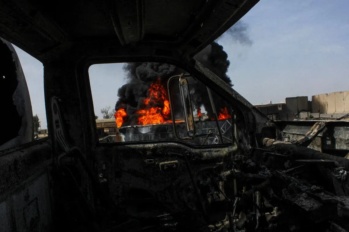 Thick black smoke is seen through a destroyed truck at the private airline Kam Air's fuel depot after a strike in what the Taliban said was a Pakistani air strike, in Kandahar, Afghanistan, March 13, 2026. REUTERS/Stringer