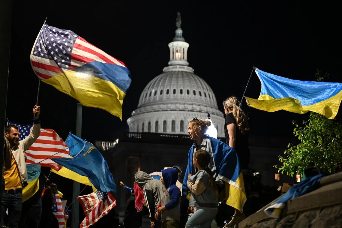 People who stand in solidarity with Ukraine wave flags and hold signs outside the US Capitol on April 23.