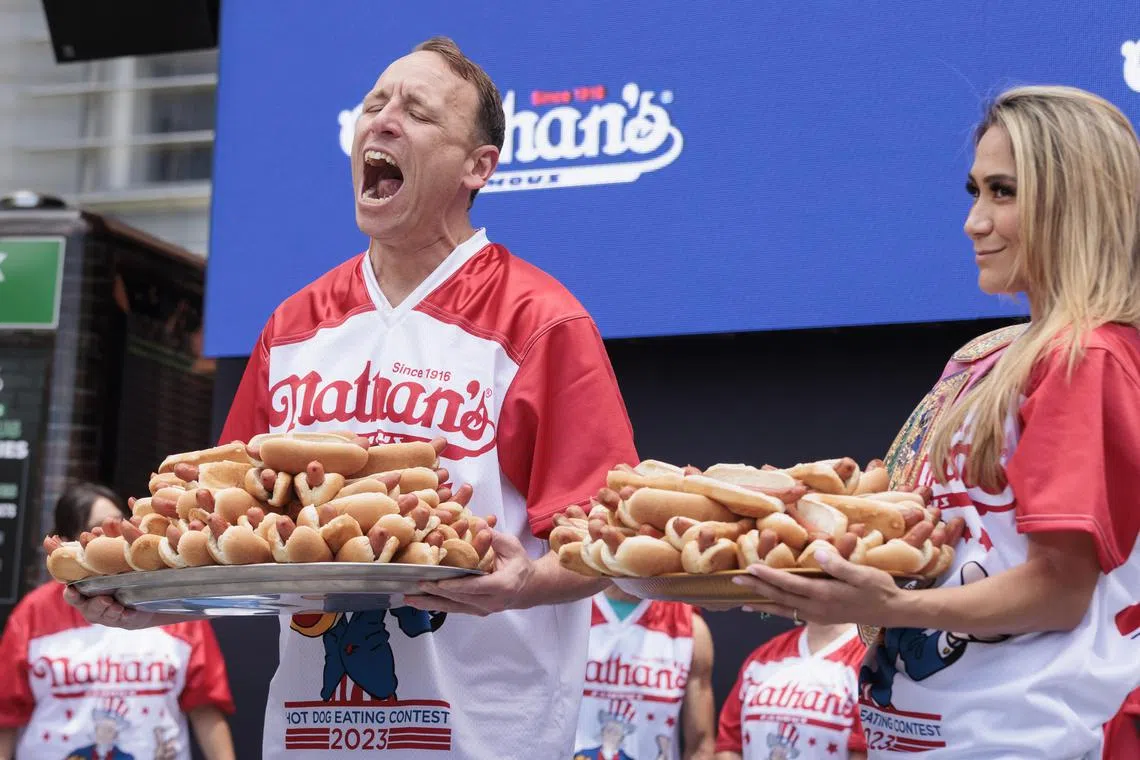 Top-ranked competitive eaters Joey Chestnut (L) and Miki Sudo (R) posing with plates of hot dogs during a weigh-in ceremony for Nathan's Famous Fourth of July International Hot Dog Eating Contest in New York on July 03, 2023. 