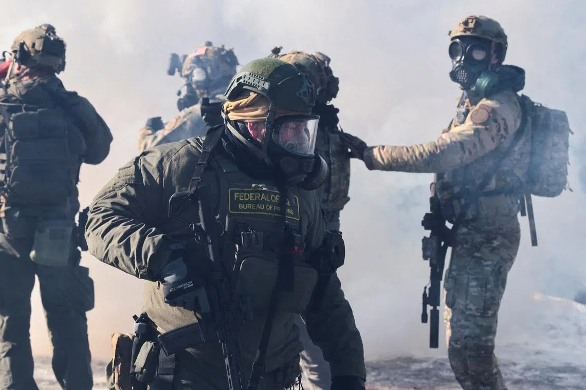 Federal agents stand amid tear gas to disperse people gathered near the scene where federal agents fatally shot a man while trying to detain him, in Minneapolis, Minnesota, U.S., January 24, 2026. REUTERS/Evelyn Hockstein