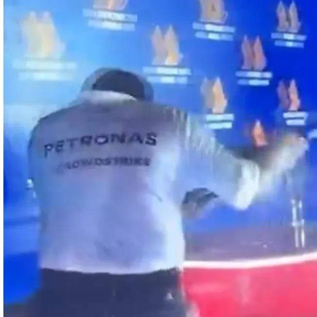 Tengku Muhammad Taufik (left) drew criticism after he was seen on the podium with Formula One Team driver George Russell when champagne was sprayed. 