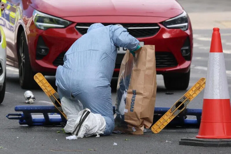A member of the forensic team uses an evidence bag, as they work at the scene, after a man was arrested following a stabbing incident in the Golders Green area, London, on April 29, 2026. 