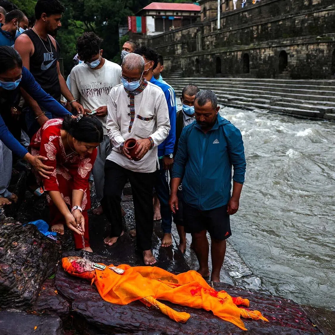 A relative of Sabin Timalsina, 21, pours water during his cremation rituals using an effigy as his body remained missing following the deadly flash floods and mudslide, on the premises of Pashupatinath Temple in Kathmandu, Nepal, September 2, 2026. REUTERS/Athit Perawongmetha TPX IMAGES OF THE DAY