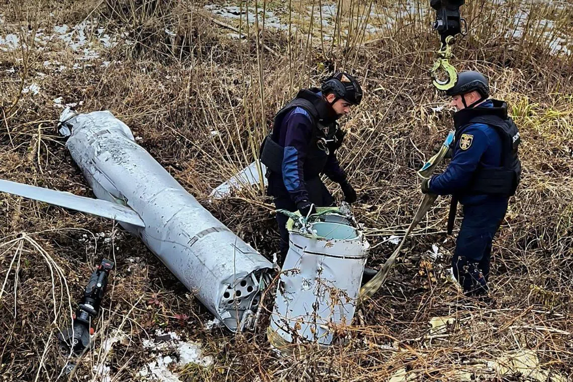 Ukrainian officials preparing to load the remains of a Russian cruise missile onto a truck, following a missile attack in Kyiv, Ukraine, on Nov 28.