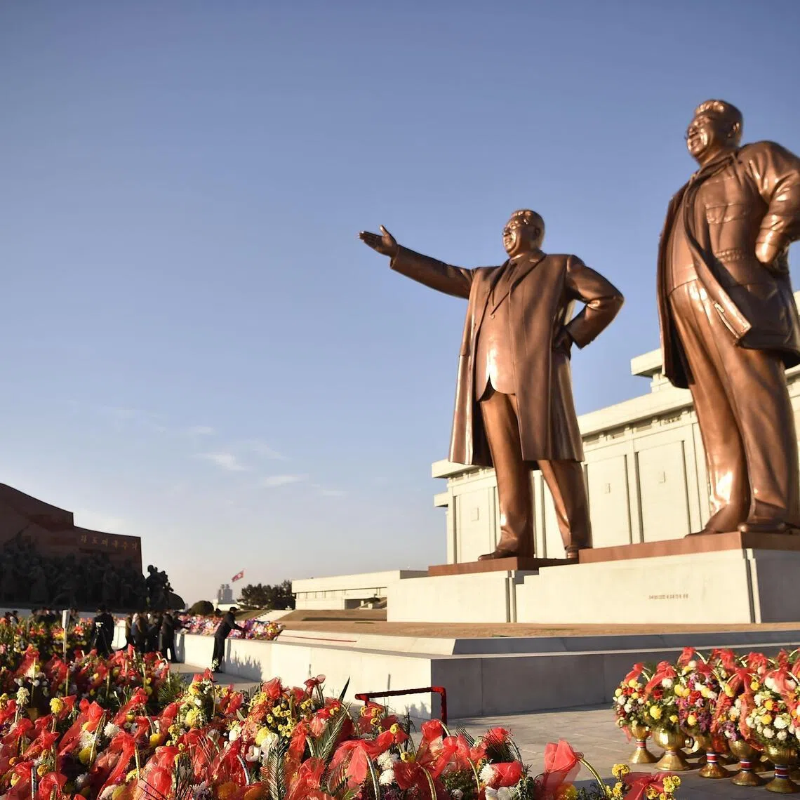 People visit the statues of late North Korean leaders Kim Il Sung and Kim Jong Il in Pyongyang. The film "Days and Nights of Confrontation" depicts a plot to kill the latter.
