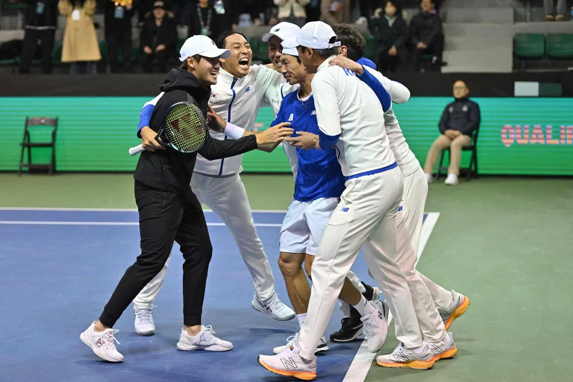 South Korea's Hong Seong-chan (centre) celebrating with his team members after defeating Belgium's Zizou Bergs during their singles match of the Davis Cup tennis qualifiers between South Korea and Belgium in Seoul on Sunday.