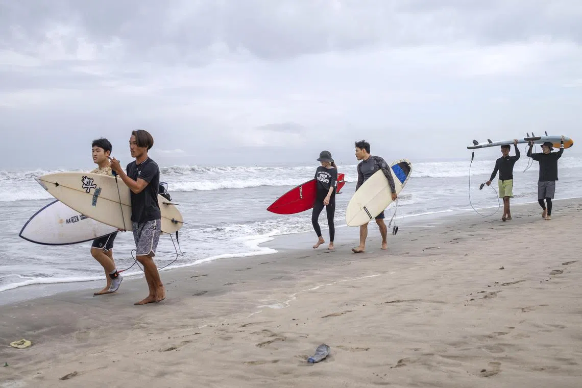 Surfers walking on Kuta beach in Bali on Wednesday. The 2023 Association of National Olympic Committees World Beach Games have been cancelled after Bali pulled out as host a month before the event’s scheduled start, organisers said Tuesday.