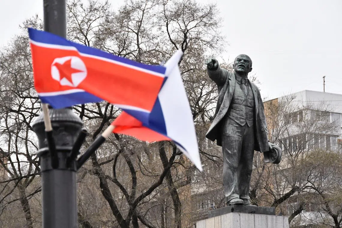 FILE PHOTO: State flags of Russia and North Korea fly in a street near a monument to Soviet state founder Vladimir Lenin during the visit of North Korea's leader Kim Jong Un to Vladivostok, Russia April 25, 2019. REUTERS/Yuri Maltsev/File Photo