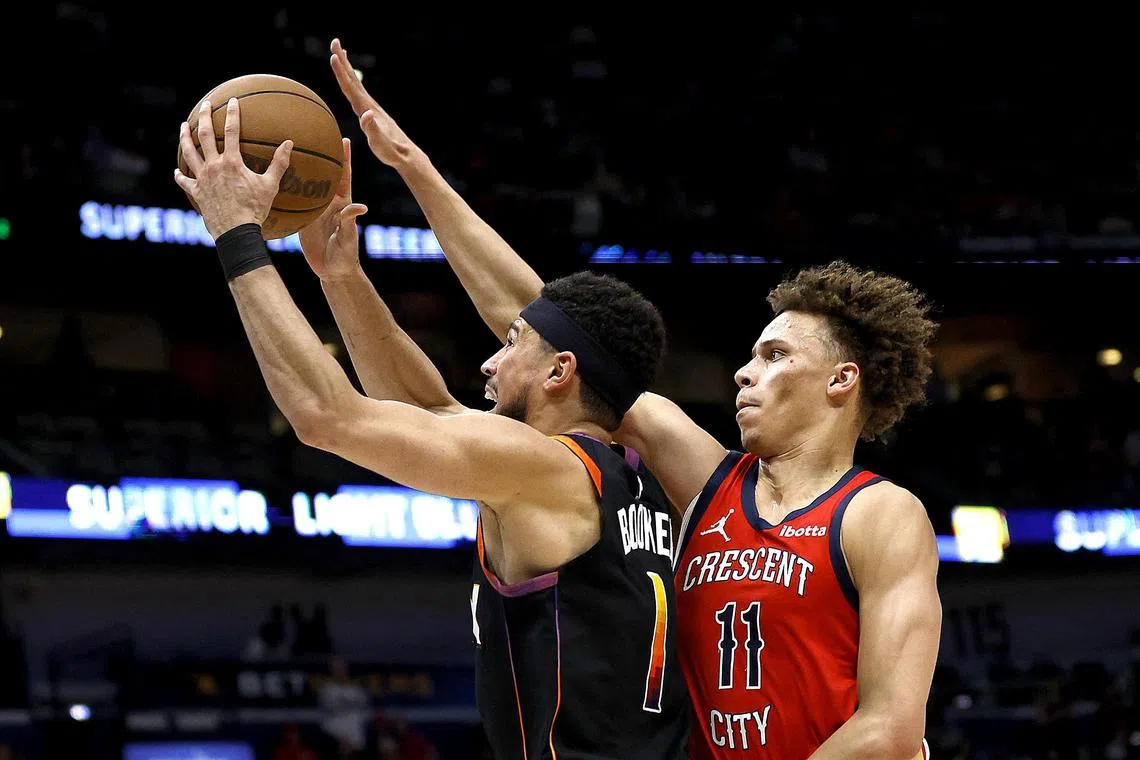 The Phoenix Suns' Devin Booker attempting a shot as the New Orleans Pelicans' Dyson Daniels attempts a block during the fourth quarter of an NBA game at Smoothie King Centre on April 1.