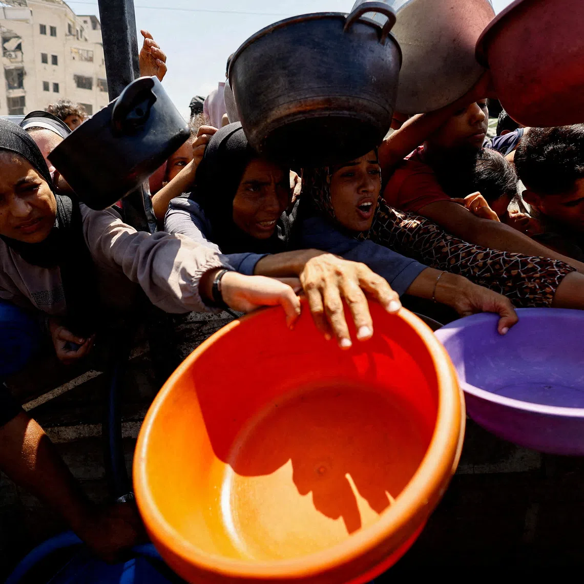 FILE PHOTO: Palestinians wait to receive food from a charity kitchen in Gaza City, August 28, 2025. REUTERS/Mahmoud Issa/File Photo