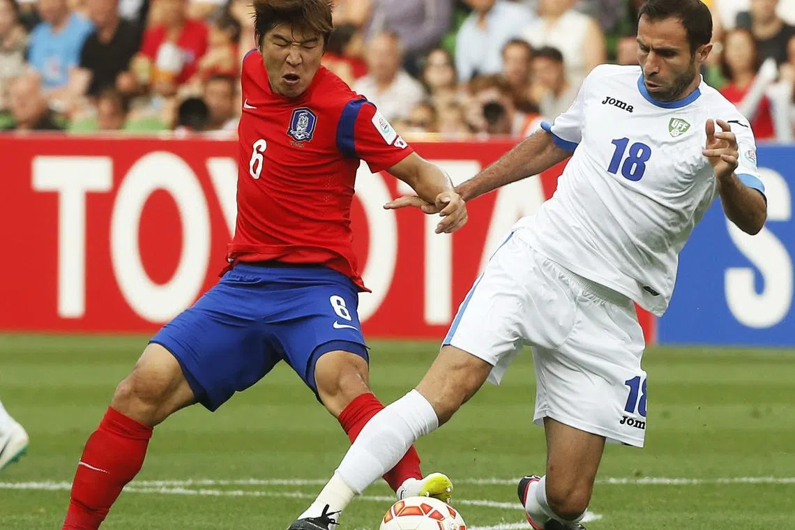 South Korea's Park Joo-ho (L) fights for the ball against Uzbekistan's Timur Kapadze during their Asian Cup quarter-final soccer match at the Rectangular stadium in Melbourne January 22, 2015. REUTERS/Brandon Malone/ File Photo