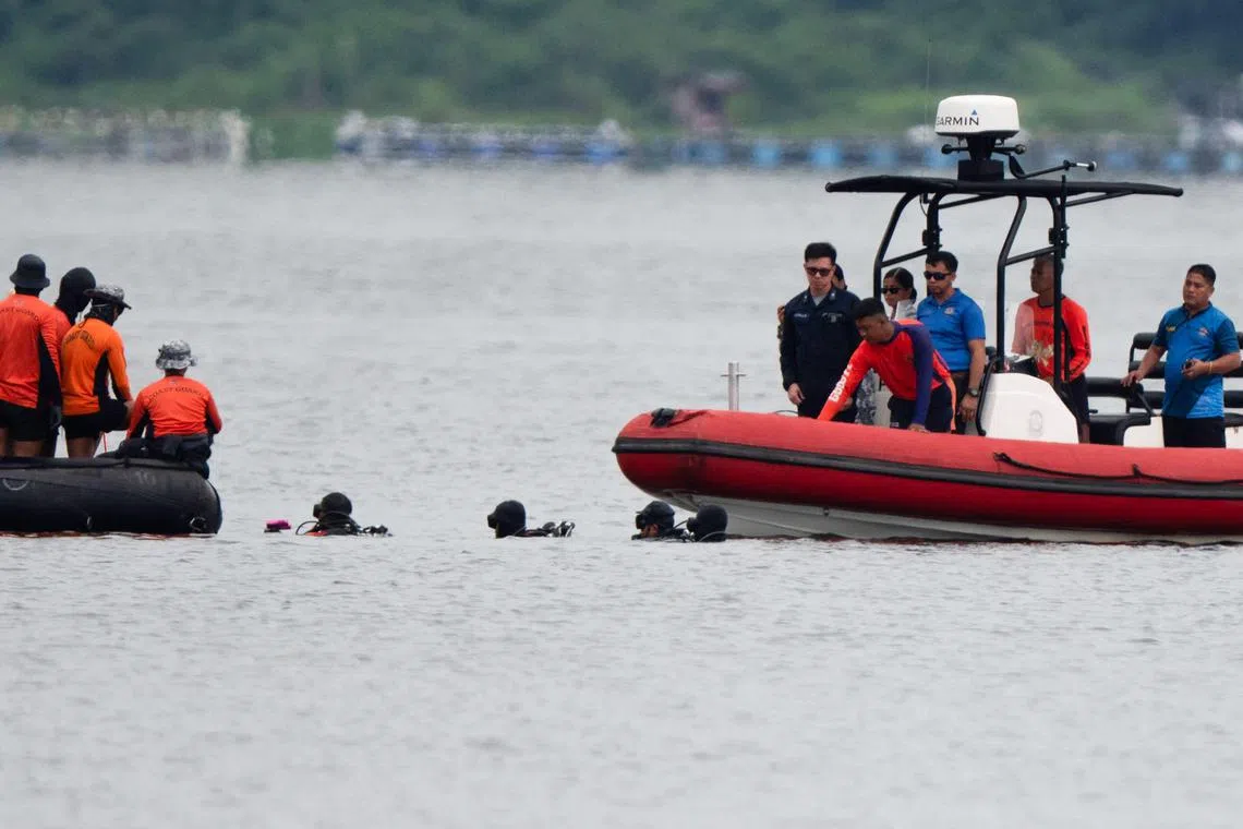 Philippine Coast Guard divers search for the remains of missing cockfighters, allegedly killed by rogue police, in Taal lake near Laurel town, Batangas province on July 17, 2025. Divers searching for dozens of murdered cockfighters in a lake south of Manila were forced to exit the water July 17 when the volcanic island in its centre erupted unexpectedly. The low-level eruption came a week into the search for the remains of people allegedly killed by rogue police for their involvement in match-fixing. (Photo by Ted ALJIBE / AFP)